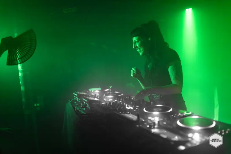 Nikki Sig smiling over the decks as a fan flicks open. Sep 2025