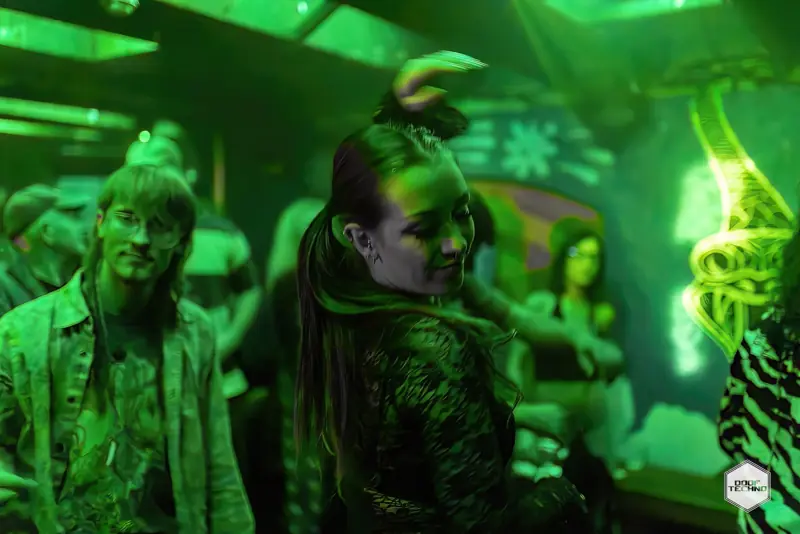 A dancer turns mid-move under green light. Launch night, May 2025