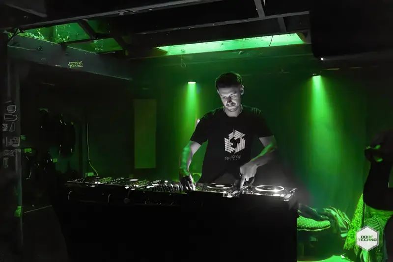 A DJ in a Techgnosis tee works the decks. Launch night, May 2025
