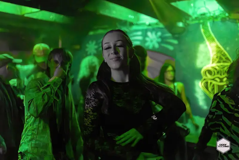 A dancer grins mid-move in front of the murals. Launch night, May 2025