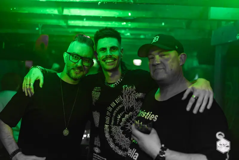 Three mates arm in arm, beaming