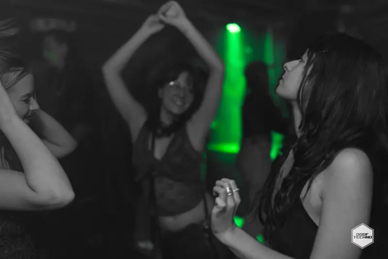 Two dancers with arms raised in the haze