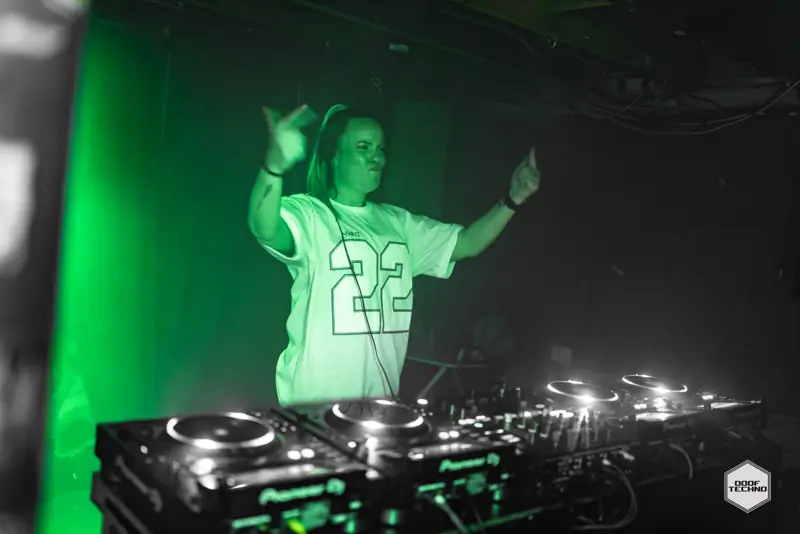 A DJ in a number 22 jersey with both hands up