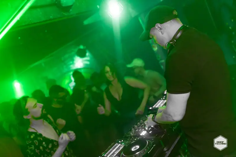 The DJ leans over the decks as the front row dances