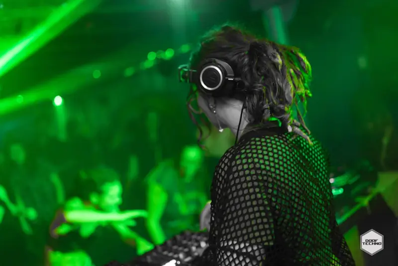 A DJ in a mesh top watches the floor