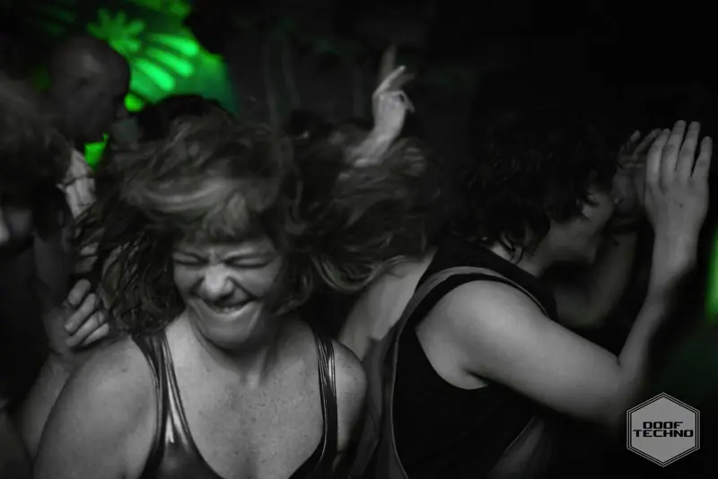 A dancer, eyes shut, grinning into the kick drum