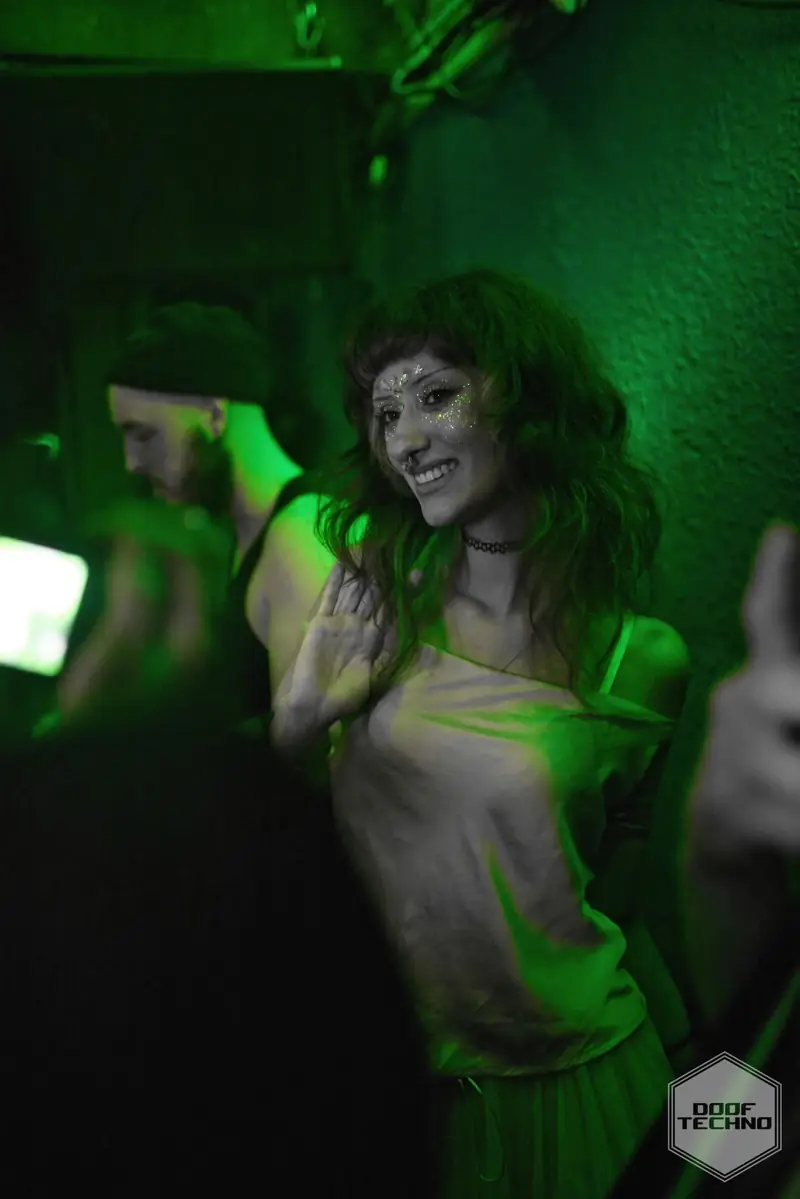 A dancer smiles in a beam of green light