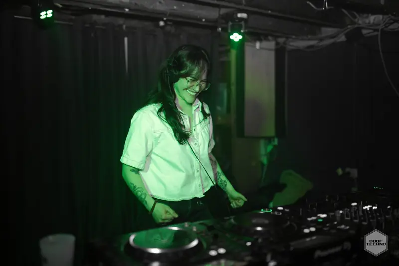 A DJ laughs behind the decks