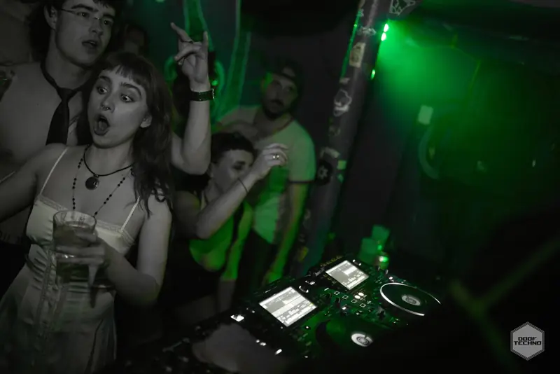 A dancer mid-cheer beside the decks