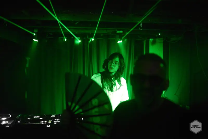 A fan snaps open in front of the booth