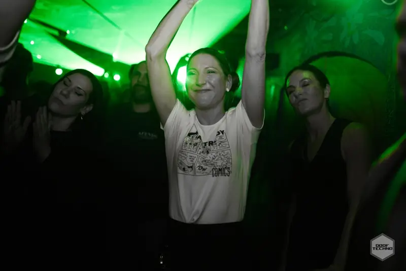 Arms raised high under the green wash